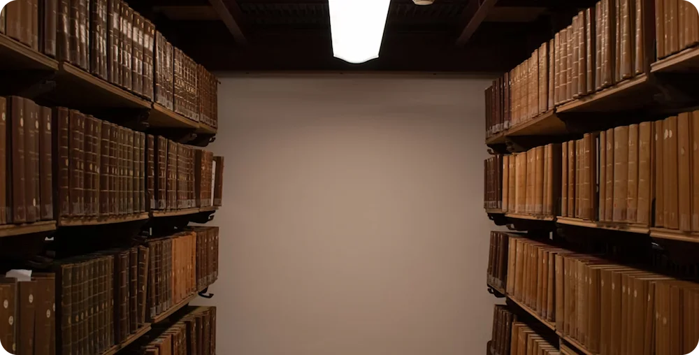 Rows of shelves filled with old books in an archive room